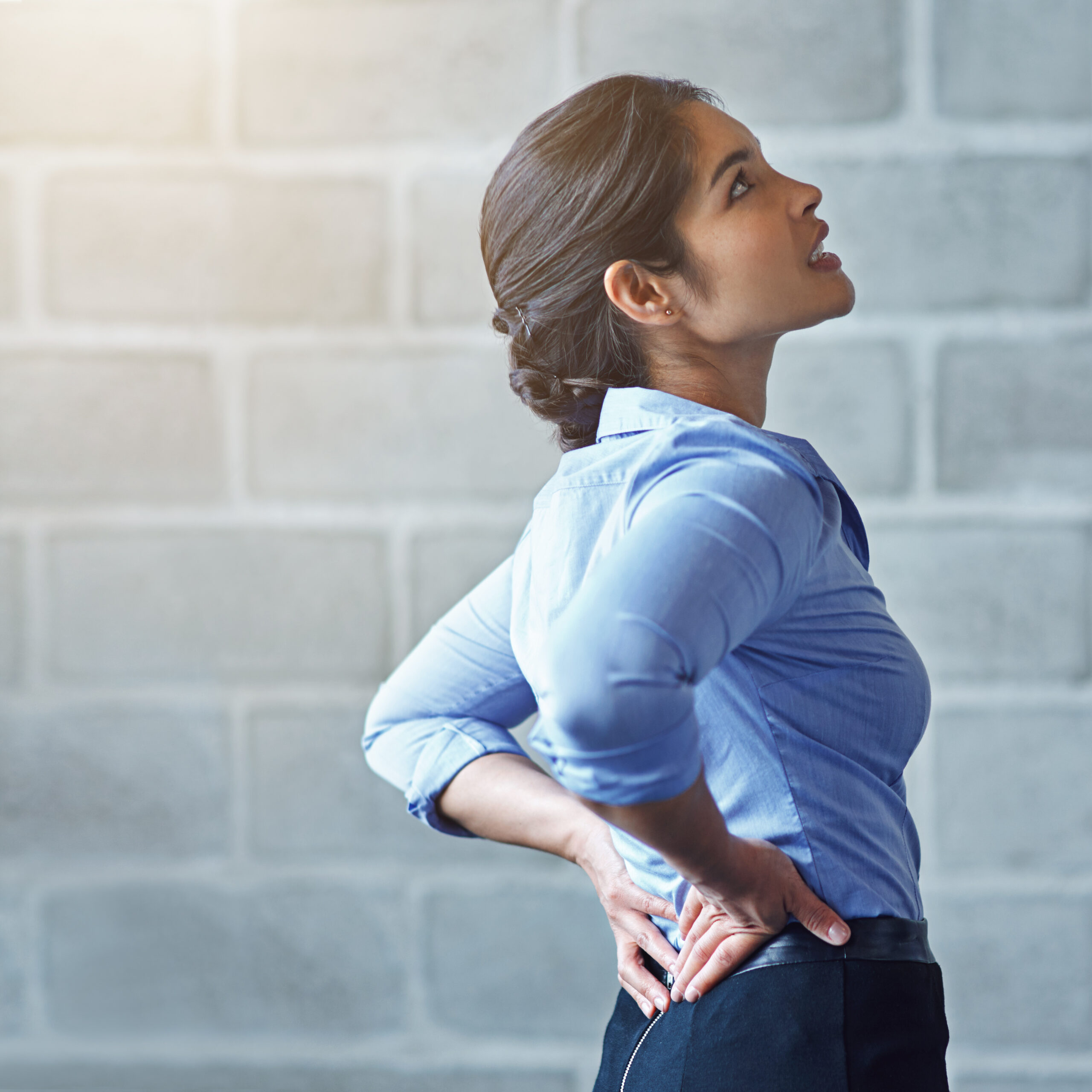 Back pain, office stress and business woman with muscle injury, health risk and fatigue on mockup wall. Uncomfortable female worker, spine problem and bad posture of injured body, scoliosis and joint.