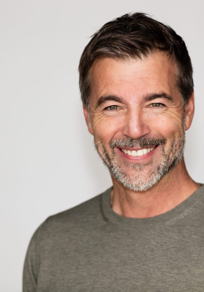 Portrait Of A Mature Man Smiling At The Camera. Right side of the picture.