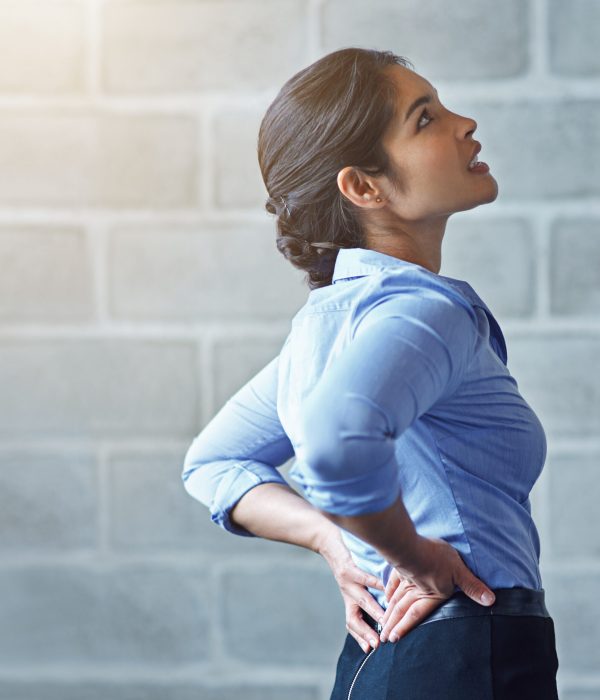 Back pain, office stress and business woman with muscle injury, health risk and fatigue on mockup wall. Uncomfortable female worker, spine problem and bad posture of injured body, scoliosis and joint.