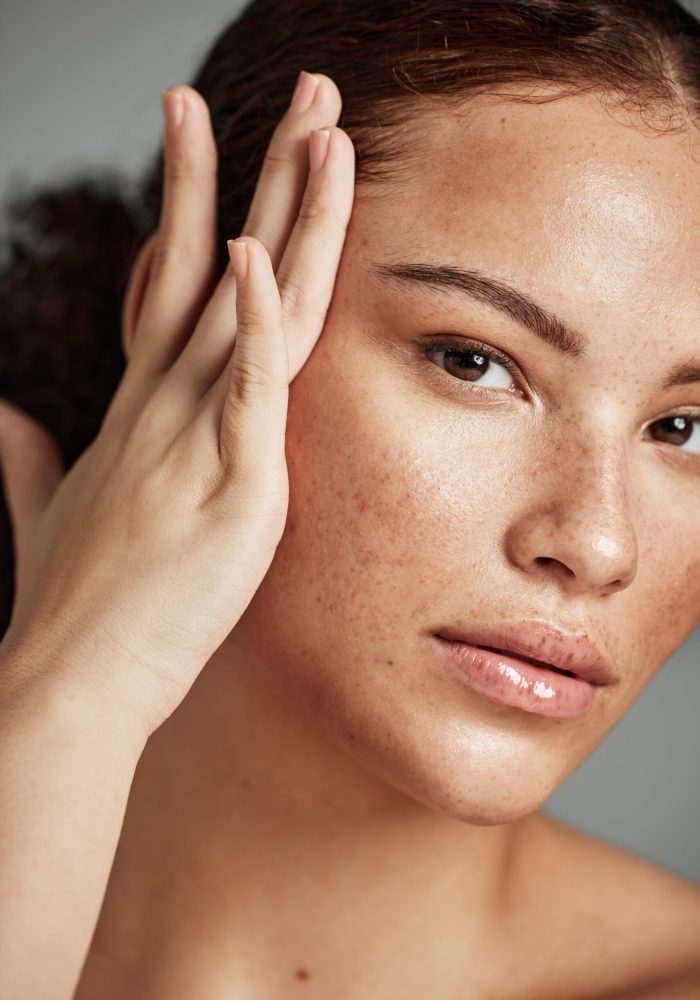 Skin, beauty and black woman portrait with skincare glow from spa treatment and makeup. Model, hand and face of a person relax after dermatology detox in a studio with gray background feeling healthy.