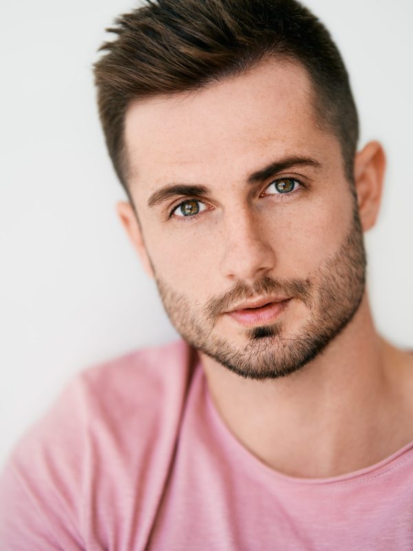 Closeup portrait of handsome sexy man looking at camera on white background. men's beauty concept