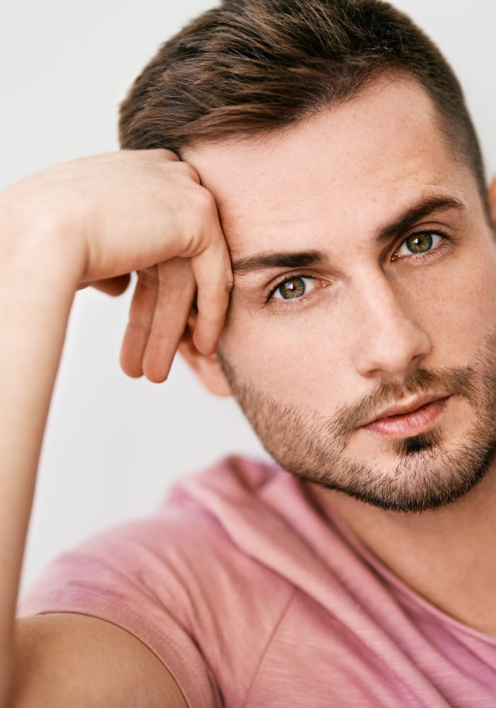 Closeup portrait of handsome sexy man looking at camera on white background. men's beauty concept